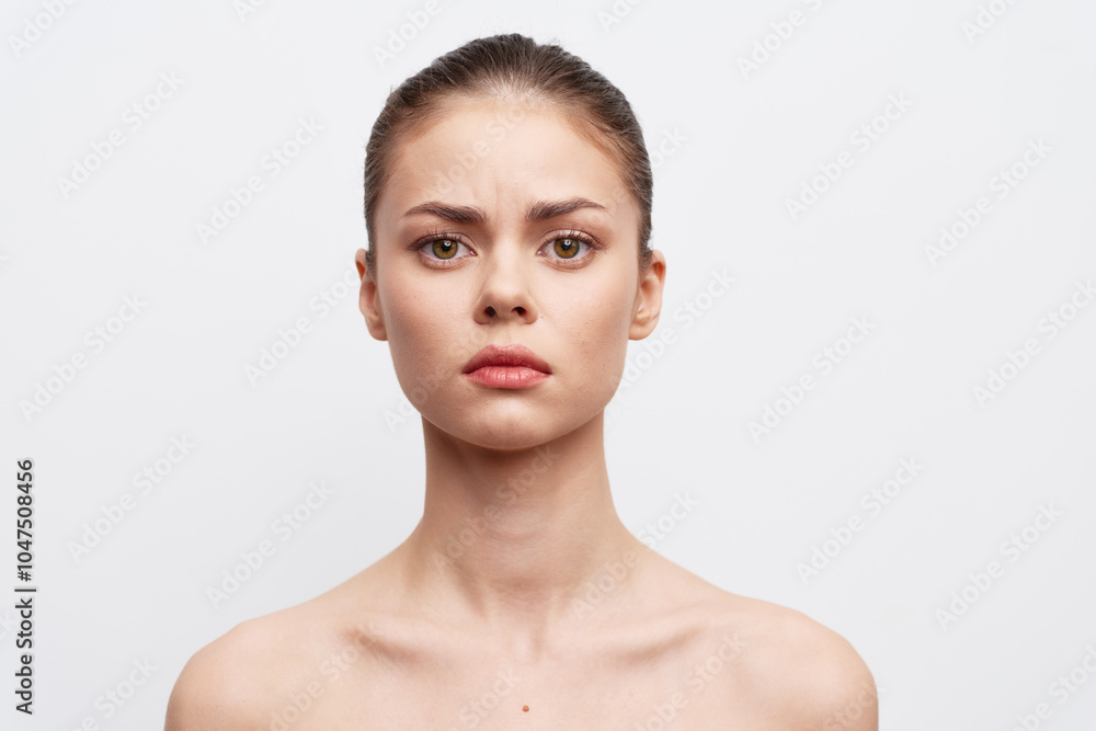 Portrait of a serious young woman with a neutral expression on a plain white background, showcasing beauty and confidence in minimalistic style The focus is on her facial features and emotions Portrait of a serious young woman with a neutral expression on a plain white background, showcasing beauty and confidence in minimalistic style The focus is on her facial features and emotions