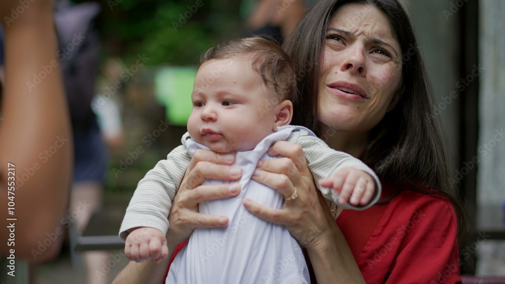 Baby held by mother, looking around curiously while sitting on her lap in an outdoor café. baby appears calm and content, exploring the surroundings with wide eyes Baby held by mother, looking around curiously while sitting on her lap in an outdoor café. baby appears calm and content, exploring the surroundings with wide eyes