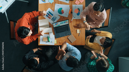 Top down view of business people analyzing data and sharing idea about financial chart. Top down aerial view of marketing team discussing about investment plan and putting hand together. Convocation.