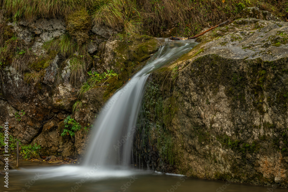 Naklejka premium Small waterfall near Jaworki village of Biala Woda creek in autumn day