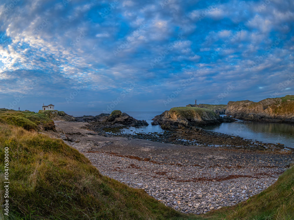 Fototapeta premium Atardecer en Valdoviño. Paisaje en el que se puede ver a la izquierda la pequeña Ermita do Porto y a la derecha el faro de Punta Foruxeira 