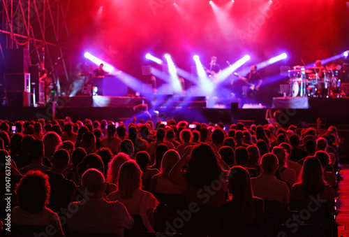 many spectators heads during a live concert with stage lights shining during the artists performance photo