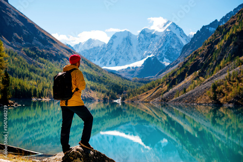 a man stands on the shore of the mountain lake Shavlinsky in Altai in autumn photo