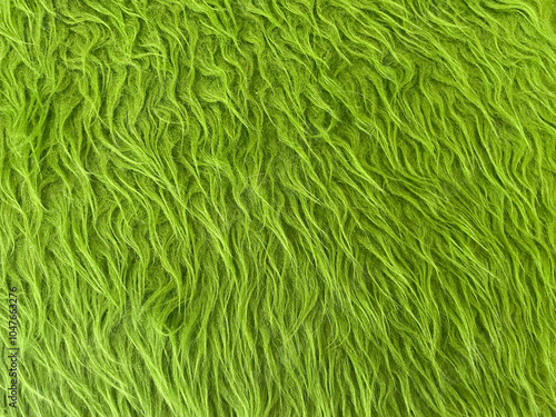 Background texture fur rug green pattern. Fluffy textile. Green carpet texture background. Close-up. Green Fabric fiber synthesis