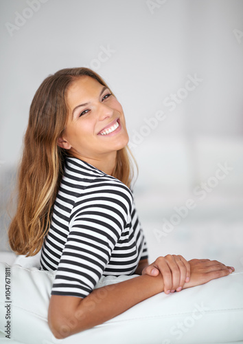 Confident, portrait and happy woman in living room on couch to relax in home or house for comfort or satisfaction. Face, smile and casual person in apartment on resting break for wellness in Spain