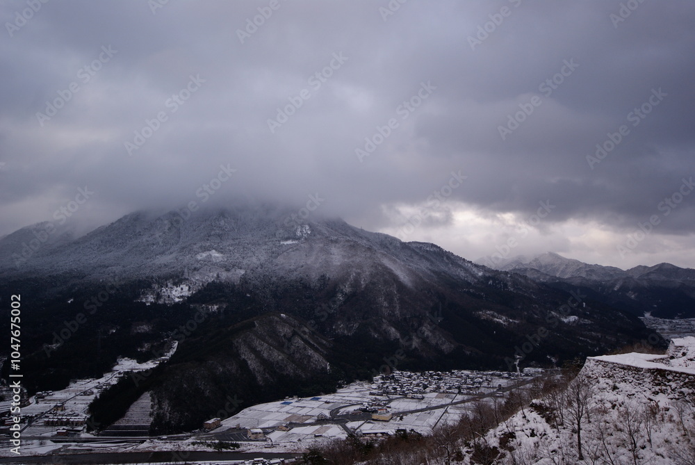 Obraz premium 雪の積もった山と竹田城跡