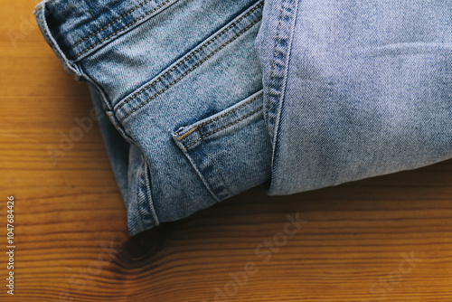 Beautiful stack of folded jeans in different shades of blue. Denim background. Jeans texture on wooden background