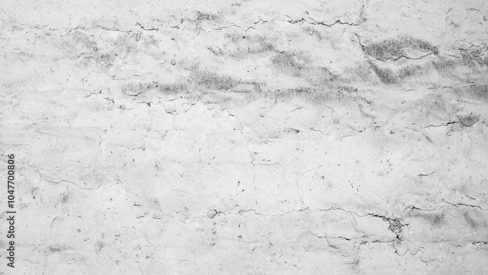 Obraz premium A white wall background with cracks and holes. The wall is made of concrete and has a rough texture
