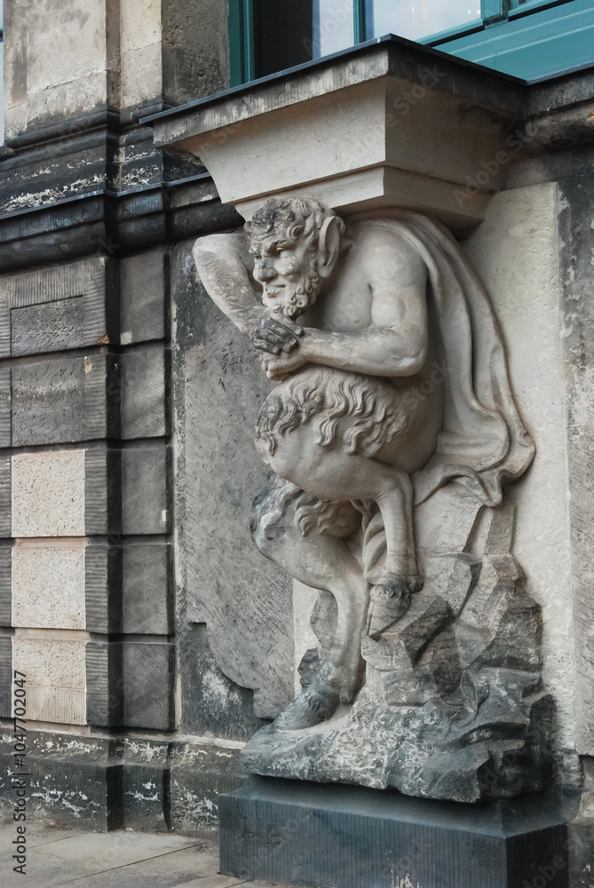 Fototapeta premium Sculpture, ancient statue of a demon, devil made of stone in a European city.