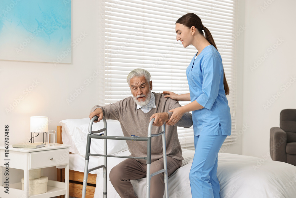 Fototapeta premium Nurse helping senior man with walking frame in clinic