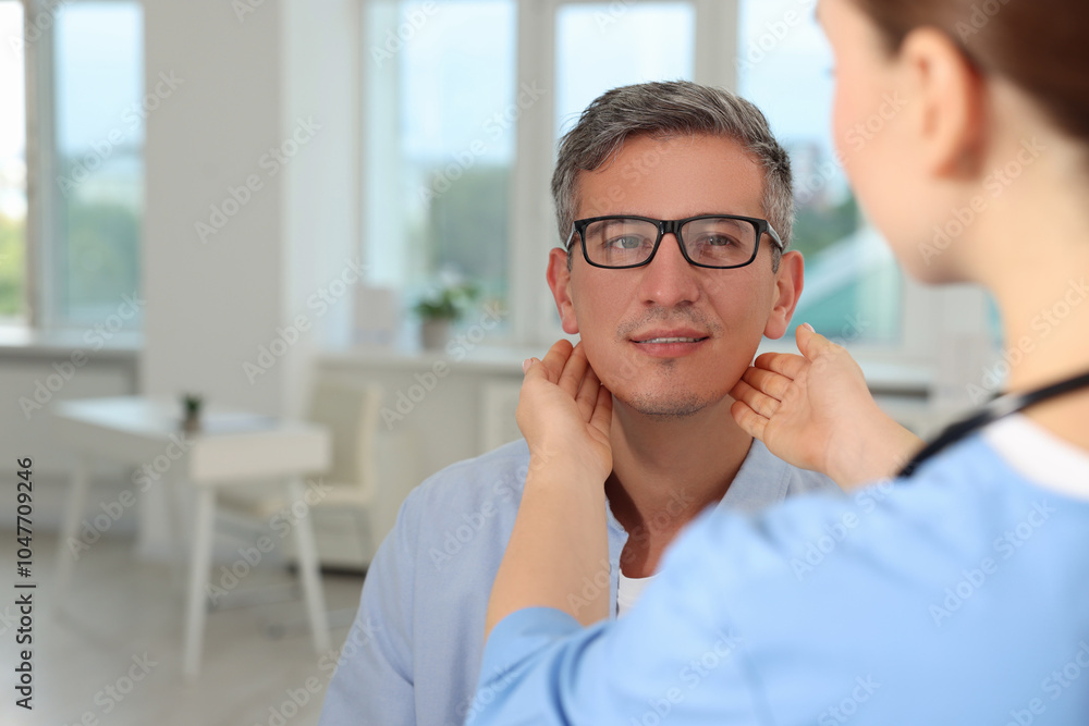 Doctor examining man's throat in clinic during appointment Doctor examining man's throat in clinic during appointment