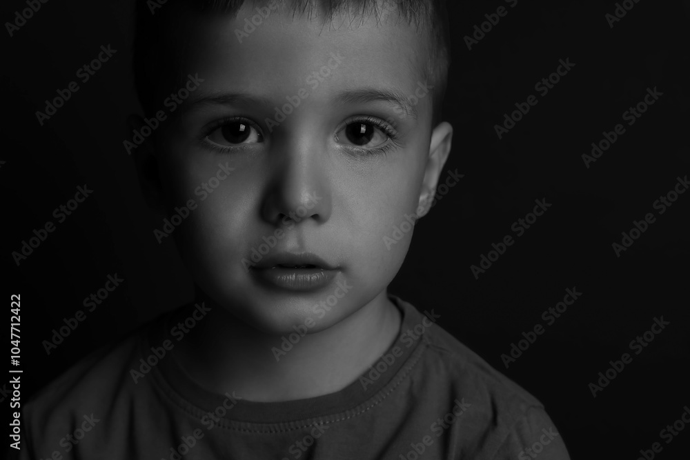 Portrait of little boy on dark background. Black and white effect Portrait of little boy on dark background. Black and white effect