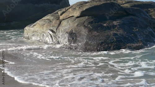 Slow-motion Shot of Waves Crashing on the Beach Rocks 3