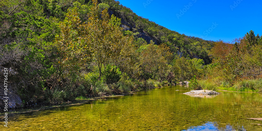 Fototapeta premium The Sabinal River meanders through the Lost Maples State Natural Area and the surrounding areas.