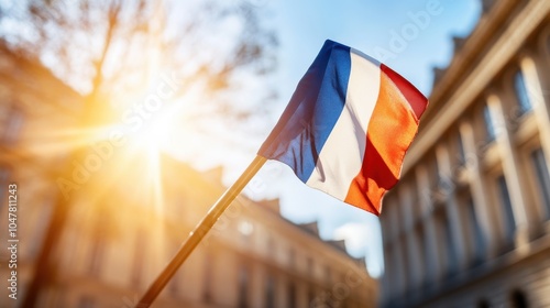 The French flag waves proudly under the bright sun, casting a radiant glow. The historic architecture backdrop reinforces a sense of national pride and timeless elegance. photo