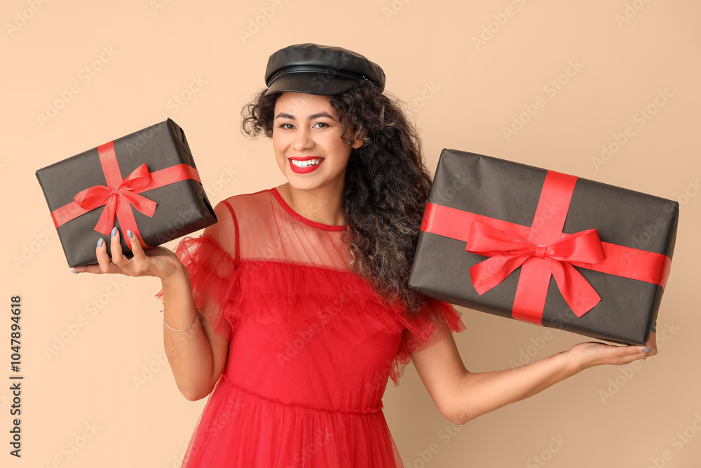 Beautiful African-American woman with gift boxes on beige background. Black Friday sale Beautiful African-American woman with gift boxes on beige background. Black Friday sale