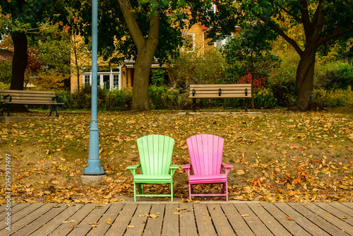 Photography Two colorful beach chairs on a wooden boardwalk in fall with a background of tre