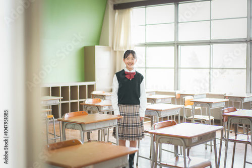 教室の中で立っている日本人の女子中学生のポートレート