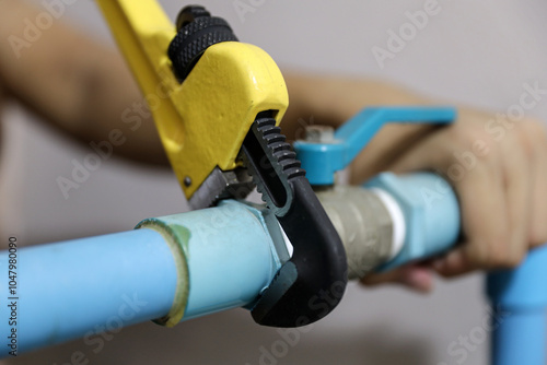 Plumber using a wrench to repair a water pipe. Concept of water pump maintenance fix water plumbing leaks drop or house bathroom service or cleaning clogged pipes is dirty or rusty. photo