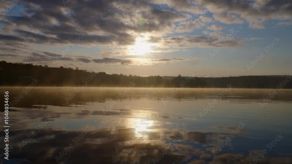 Beautiful sunrise with clouds reflecting on calm water under the morning sky Beautiful sunrise with clouds reflecting on calm water under the morning sky