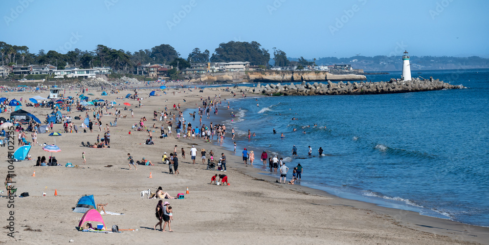 sunbathers on beach with light house sunbathers on beach with light house