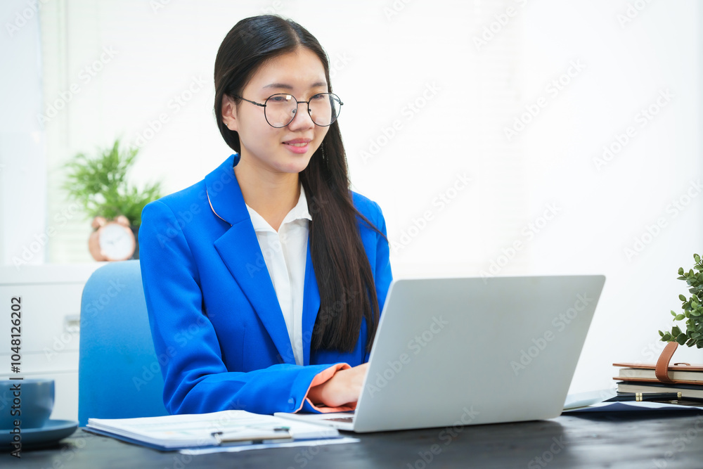 An Asian businesswoman sits at her desk in the office, discussing her work on a business plan. She emphasizes strategic planning, target group identification, and comprehensive business analysis An Asian businesswoman sits at her desk in the office, discussing her work on a business plan. She emphasizes strategic planning, target group identification, and comprehensive business analysis