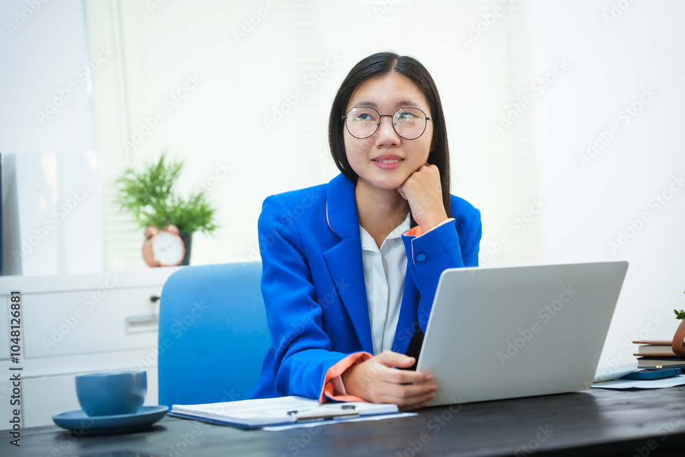 An Asian businesswoman sits at her desk in the office, discussing her work on a business plan. She emphasizes strategic planning, target group identification, and comprehensive business analysis An Asian businesswoman sits at her desk in the office, discussing her work on a business plan. She emphasizes strategic planning, target group identification, and comprehensive business analysis