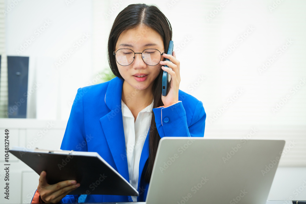 An Asian businesswoman sits at her desk in the office, discussing her work on a business plan. She emphasizes strategic planning, target group identification, and comprehensive business analysis An Asian businesswoman sits at her desk in the office, discussing her work on a business plan. She emphasizes strategic planning, target group identification, and comprehensive business analysis