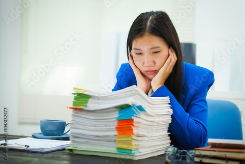 Quadro su tela A businesswoman sits at her desk in the office, exhausted and stressed from checking company documents
