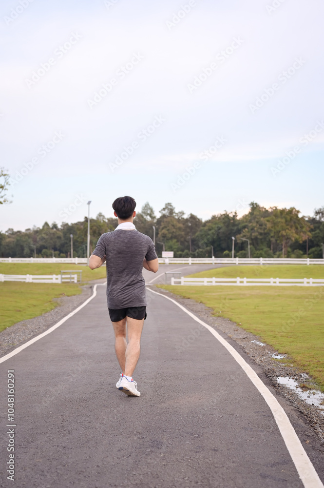Athletic man jogging in a peaceful park. Fitness and healthy lifestyle concept Athletic man jogging in a peaceful park. Fitness and healthy lifestyle concept