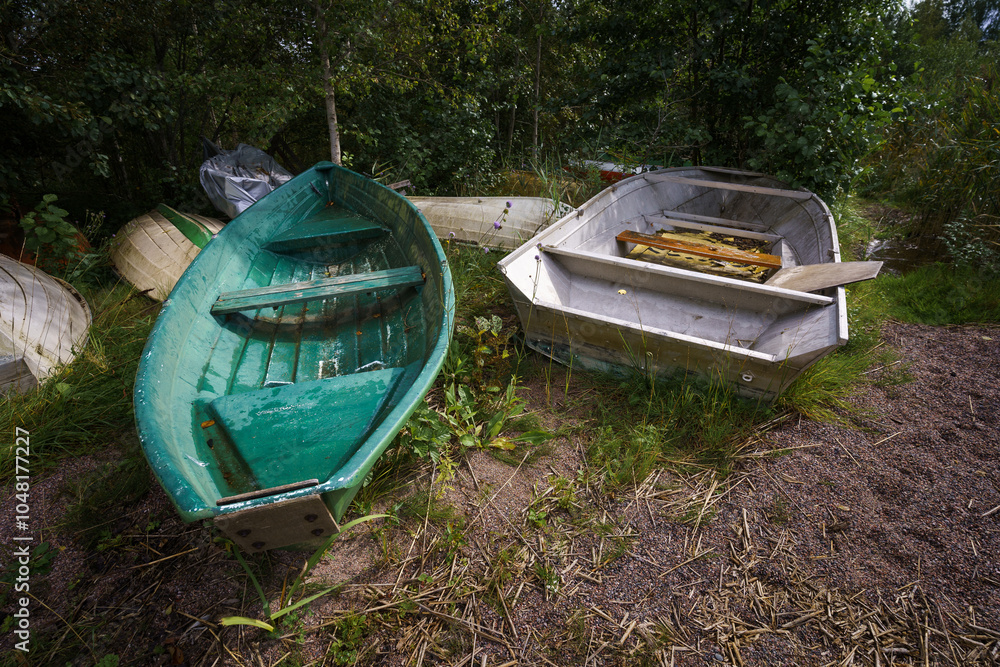 Abandoned boats resting on a grassy area Abandoned boats resting on a grassy area