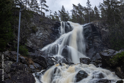 Landscape shot of a large waterfall in the forest and nature. Autumn landscape The Elgafossen Vattenfall river provides a natural border between Sweden and Norway at Vassbotten, Scandinavia photo