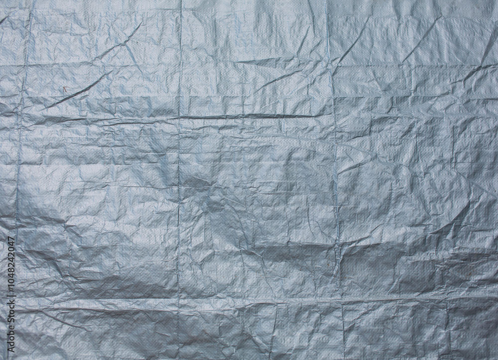 Fototapeta premium The wrinkled texture of the gray canvas background