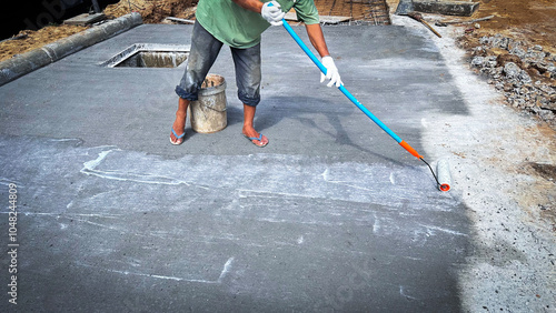 Foto Technician applies concrete curing agent to prevent cracking