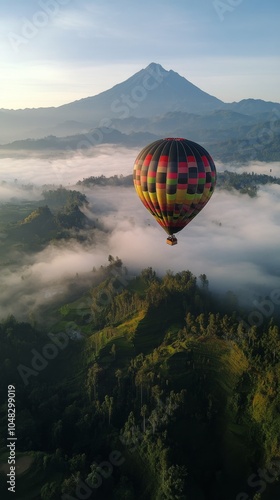 Hot air balloon soaring over volcanic landscape at dawn with clouds enveloping the earth photo