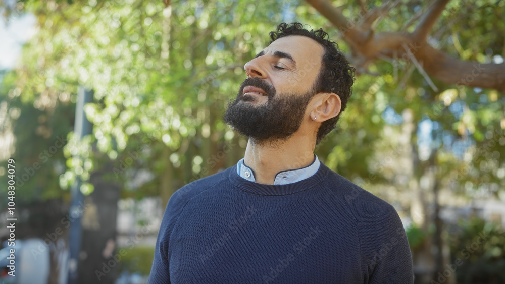 Bearded man enjoying sunshine in a green park setting with blurred background, invoking feelings of relaxation and contentment. Bearded man enjoying sunshine in a green park setting with blurred background, invoking feelings of relaxation and contentment.