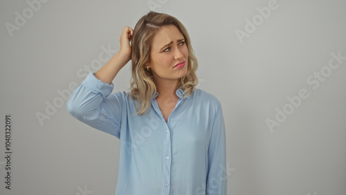 Konstfotografi Puzzled young blonde woman in blue shirt with a white background expressing doubt and uncertainty