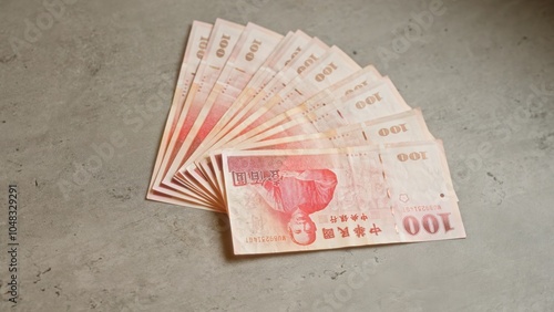 Chinese yuan banknotes fanned out on a concrete surface, showcasing the currency's intricate design and highlighting the financial elements in a neutral setting. photo