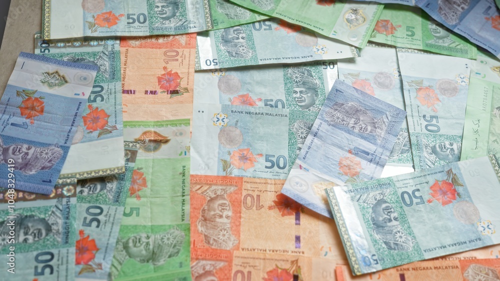 Obraz premium Malaysian ringgit banknotes scattered on a surface showcasing various denominations and vibrant colors representing currency in malaysia.