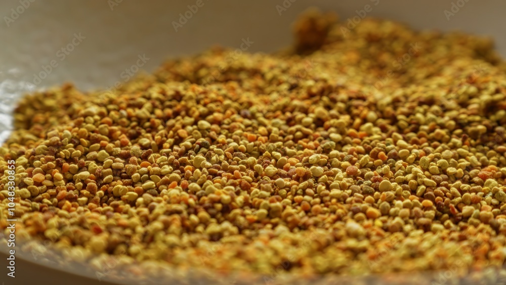 Macro photograph showing a close-up of dried, yellow, bee pollen grains, highlighting their texture and color in a bowl. Macro photograph showing a close-up of dried, yellow, bee pollen grains, highlighting their texture and color in a bowl.