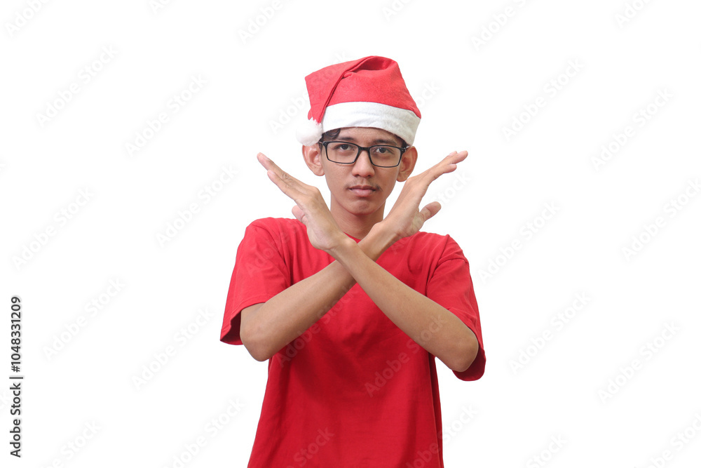 Portrait of excited Asian man in red t-shirt with santa hat showing X sign of hands. Teenager refusing an invitation from someone. Isolated image on white background Portrait of excited Asian man in red t-shirt with santa hat showing X sign of hands. Teenager refusing an invitation from someone. Isolated image on white background