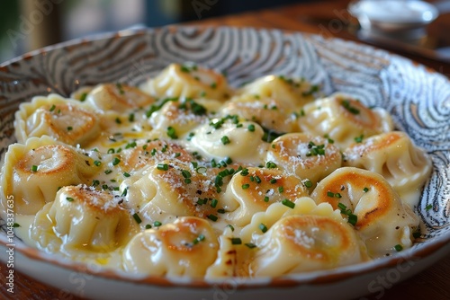 A serving of pelmeni, Russian dumplings filled with meat, topped with melted butter and a sprinkle of chives photo