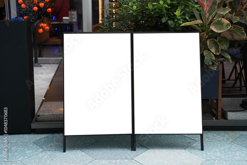 Obraz na płótnie Blank white outdoor advertising stand sandwich board mock up template. Clear street signage board placed by an outdoor dinning area of a restaurant. w salonie