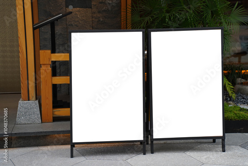 Obraz na płótnie Blank white outdoor advertising stand sandwich board mock up template. Clear street signage board placed by an outdoor dinning area of a restaurant. w salonie