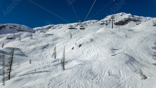 Colere, Italy. Chairlift with skiers is moving to the top of the ski runs in a wonderful sunny day