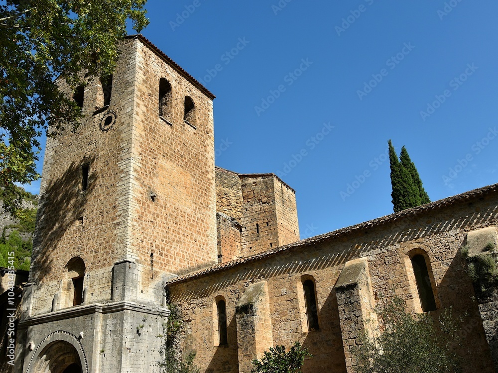 Le clocher et la façade de l’église abbatiale de Gellone de Saint-Guilhem-le-Désert dans l’Hérault Le clocher et la façade de l’église abbatiale de Gellone de Saint-Guilhem-le-Désert dans l’Hérault
