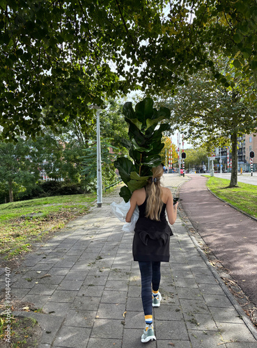 woman walking on street with plant