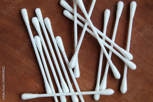 New white cotton buds or cotton swab or Q-tips, on wooden background, top view photo