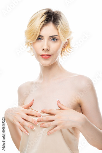 A young blonde girl with clear skin in a satin top. Beauty portrait of a woman on a white background in the studio.