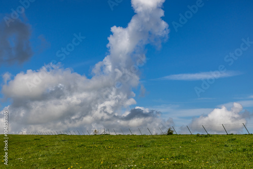 A view in the Sussex countryside with dramatic clouds over a green field photo